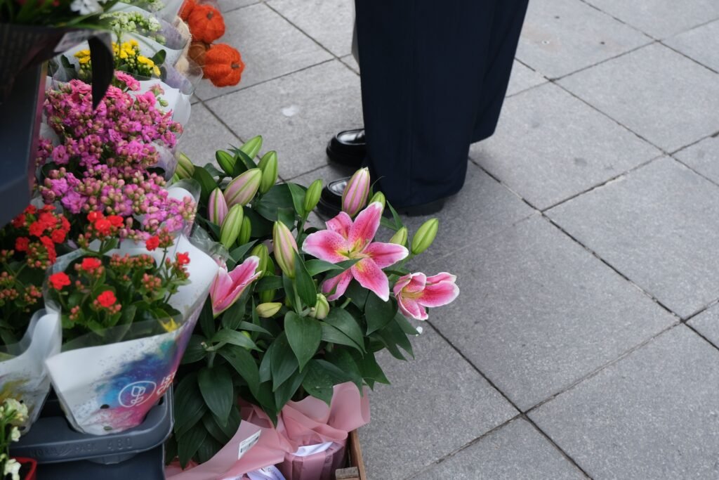Vibrant flower bouquets displayed on a city sidewalk, ideal for market or urban themes.
